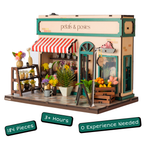 Model of a flower shop with 'petals & posies' sign, surrounded by flowers and plants.