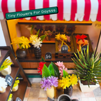 Close-up of miniature flower buckets and shopfront details at Petals and Posies
